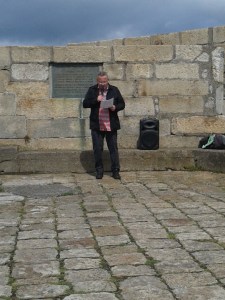 John Crawley giving his oration with the plaque commemorating the landing of the Howth guns behind him