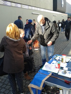People signing the Save Moore Street From Demolition campaign petition in Moore Street with the new hoarding for the ILAC's latest extension in the background. (Photo: D.Breatnach)
